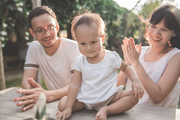 Parents with kid taking care of flowe — Stock Photo, Image