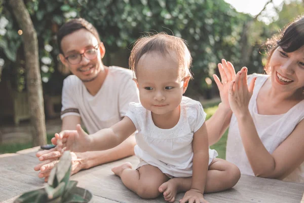 Parents with kid taking care of flowe — Stock Photo, Image