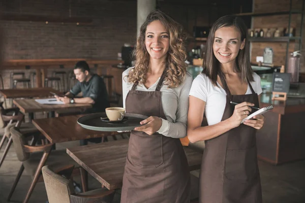Två vackra kvinnliga servitrisen leende till kamera — Stockfoto