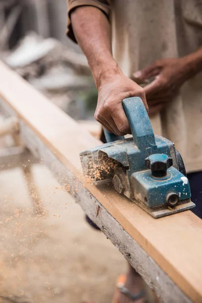 Worker grinds wood