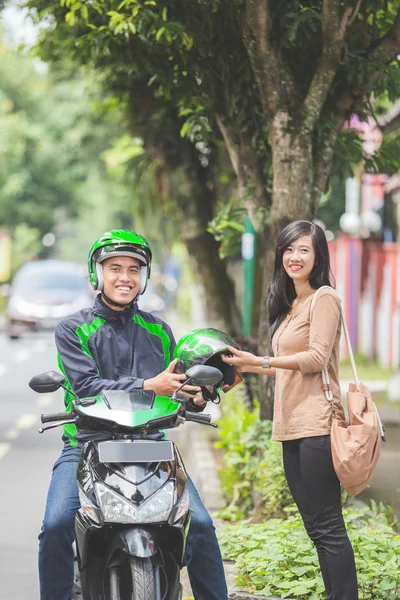 taxi driver giving helmet to customer