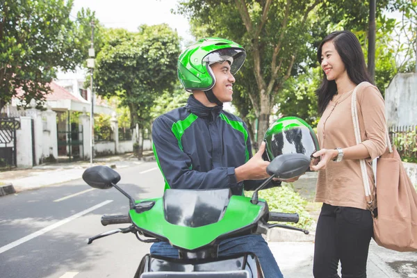 taxi driver giving helmet to customer