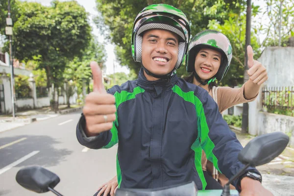 Taxista de motocicleta comercial y su pasajero mostrando thum —  Fotos de Stock