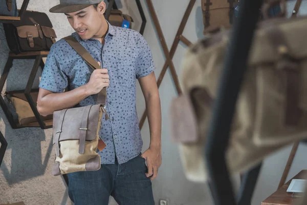 Man probeert een nieuwe tas bij een winkel — Stockfoto