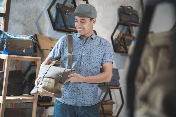 Man probeert een nieuwe tas bij een winkel — Stockfoto