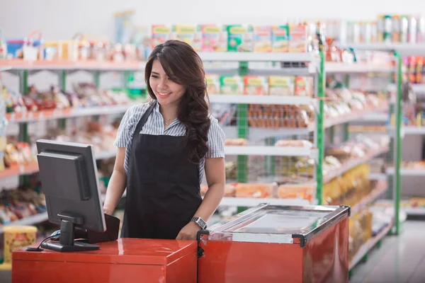 Female staff standing at cash counter — Stock Photo, Image