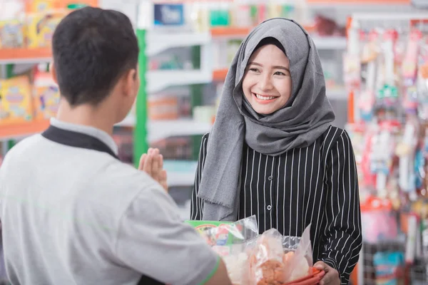 Male shopkeeper or cashier welcoming customer — Stock Photo, Image