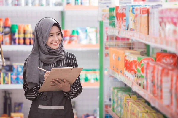 Muslimsk kvinna kontrollera produkten i butiken — Stockfoto
