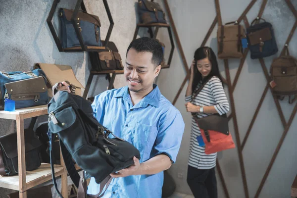 Man probeert een nieuwe tas bij een winkel — Stockfoto