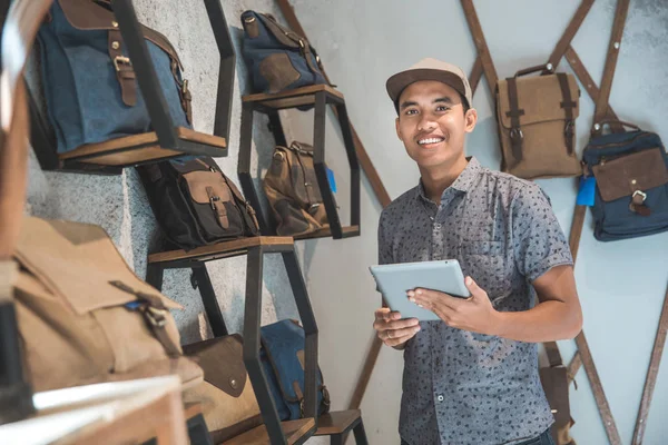 Aziatische mannelijke ondernemer in een tas winkel met tablet — Stockfoto