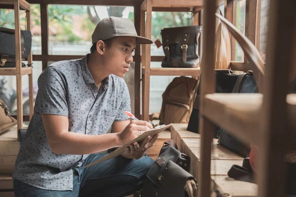 Asiatisk butik manager kontrollera produkten — Stockfoto