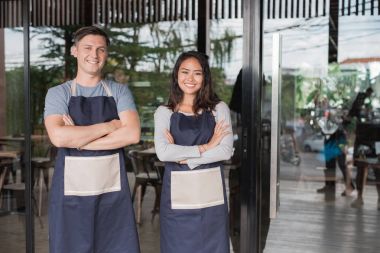 kafede kameraya gülümseyen iki Kafe sahibi