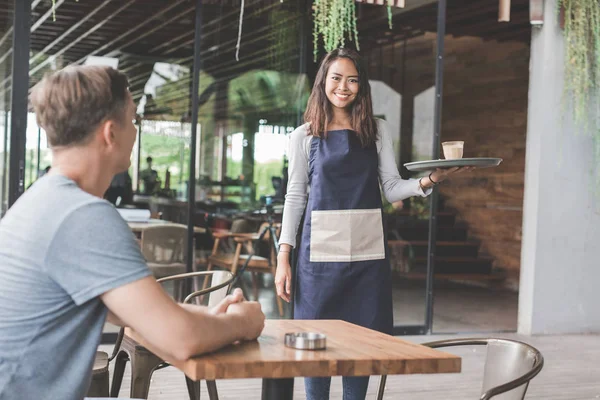 Офіціантка, що подає каву клієнту — стокове фото