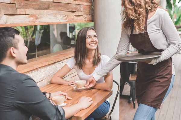 Garson kahve çift müşteriye hizmet veren