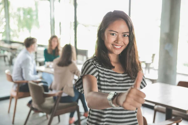 asian young woman showing thumb up