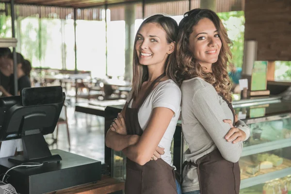 Дві красиві жіночі офіціантки посміхаються до камери — стокове фото