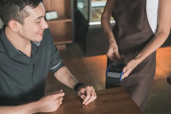 Cliente pagando suas contas usando cartão de crédito — Fotografia de Stock