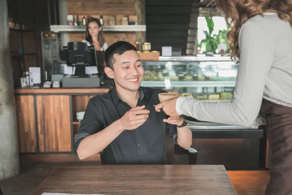 Servitrisen serverar kaffe till en kund — Stockfoto