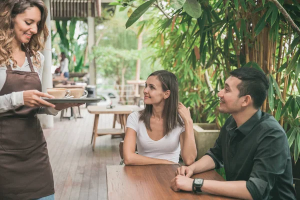 Garson kahve çift müşteriye hizmet veren