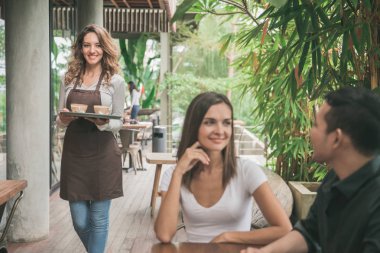 Garson kahve çift müşteriye hizmet veren