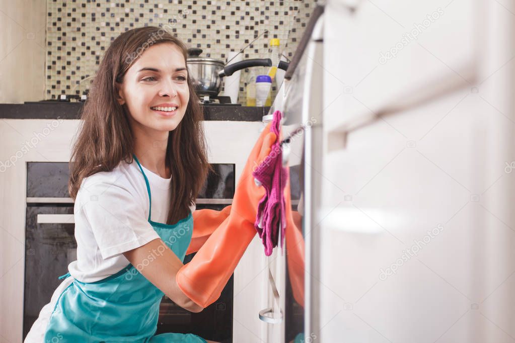 Smiling woman cleaning kitchenware