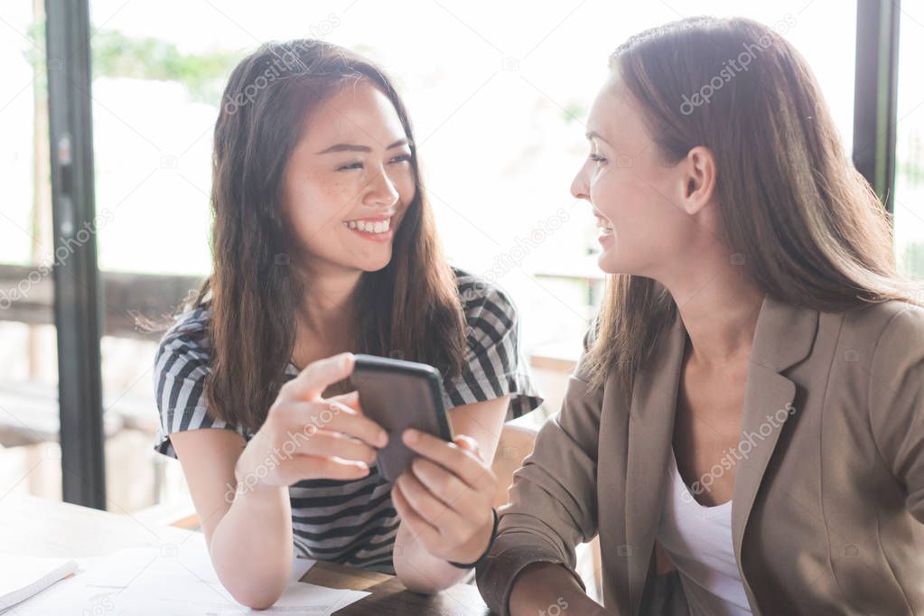 Two women sharing content on smartphone 