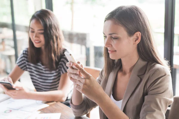 Vrouwen kijken naar smartphones — Stockfoto