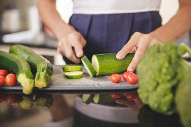 Kadın salata için sebze hazırlıyor.