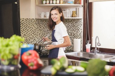 Pişirme sırasında gülümseyen kadın