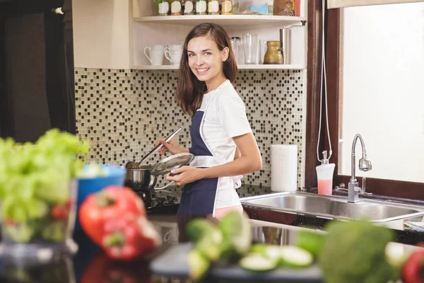 Pişirme sırasında gülümseyen kadın