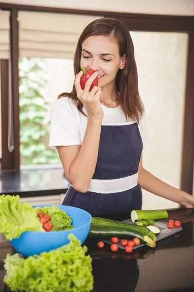 Frau riecht roten Paprika — Stockfoto