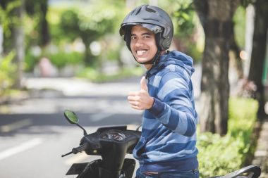 Adam yukarı başparmak shoving motosiklet üzerinde 