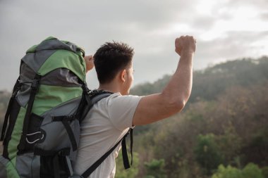 Silah tepe üzerinde yükselterek uzun yürüyüşe çıkan kimse
