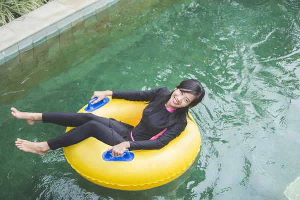 Frau im Schwimmkreis blickt in Kamera — Stockfoto