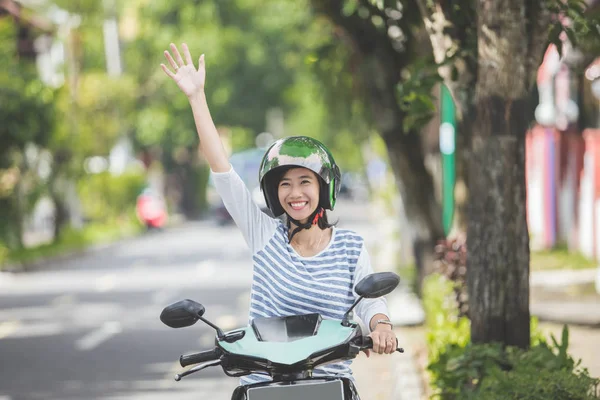 Kobieta na motocyklu, macha ręką — Zdjęcie stockowe