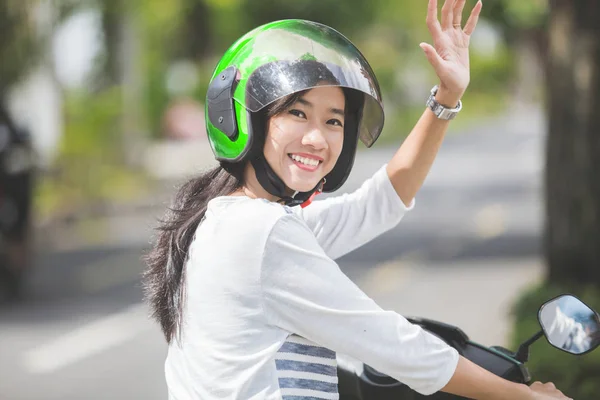 Vrouw op motor zwaaien hand — Stockfoto