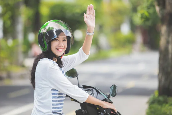 Kobieta na motocyklu, macha ręką — Zdjęcie stockowe