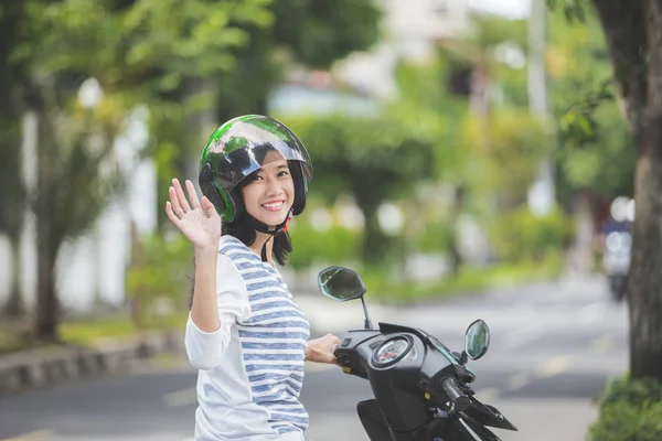 Kobieta na motocyklu, macha ręką — Zdjęcie stockowe