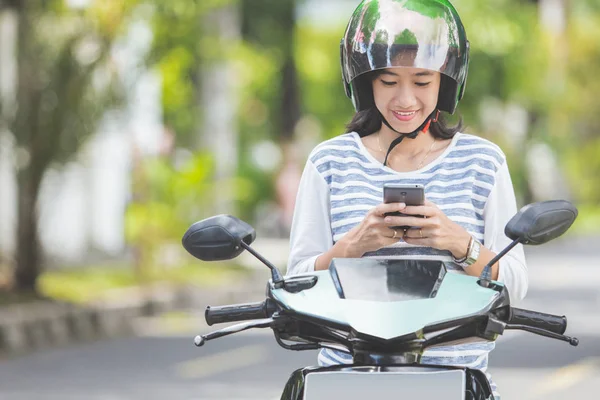 Vrouw met behulp van smartphone op motor — Stockfoto