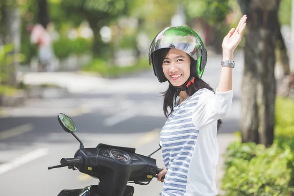 Femme sur moto agitant la main — Photo