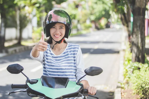 Woman on motorbike shoving thumb up — Stock Photo, Image