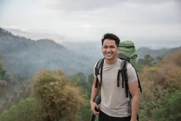 Caminante con mochila sonriendo en el pico — Foto de Stock