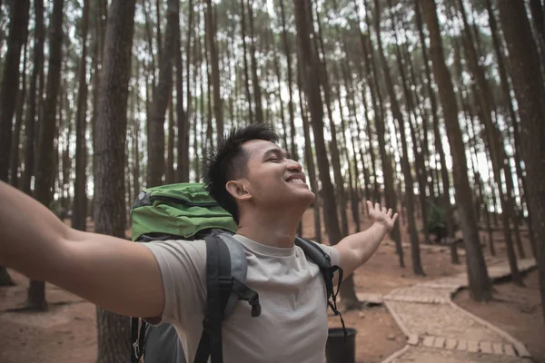 Escursionista alzando le braccia nella foresta — Foto Stock