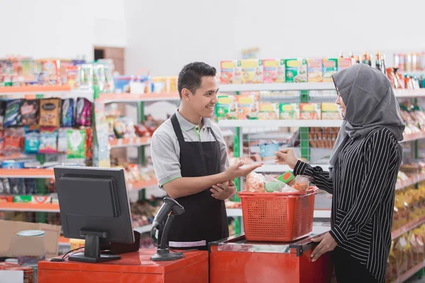 Mulher muçulmana pagando suas compras — Fotografia de Stock