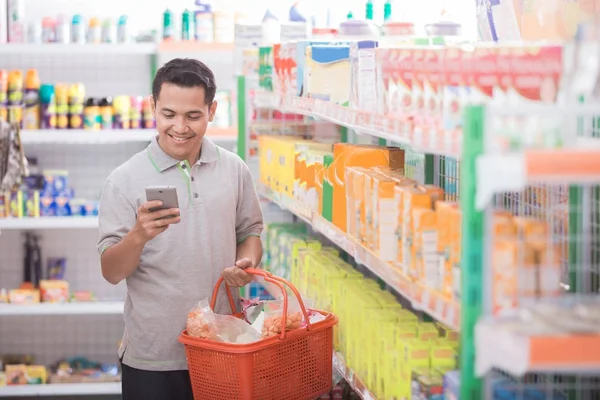 Mladý muž nakupuje v supermarketu — Stock fotografie