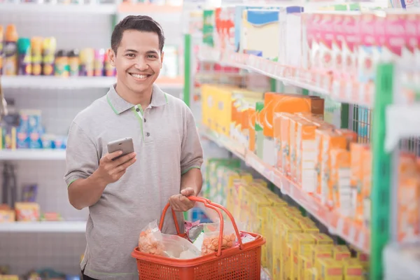 Man with shopping list at his phone — Stock Photo, Image