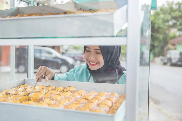 Woman taking sweets with tweezers at street — Stock Photo, Image