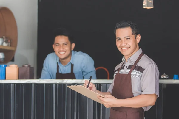 Waiter in apron writing order — Stock Photo, Image