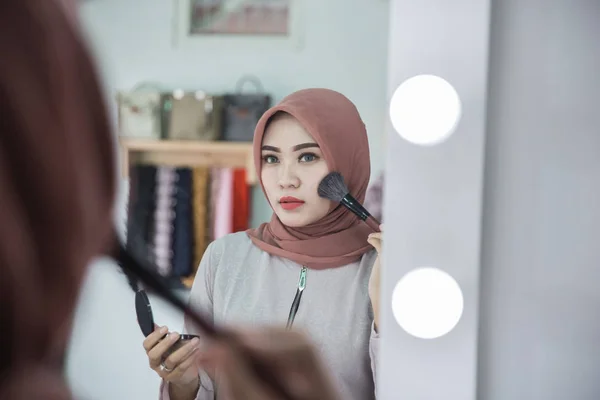 Mujer con hijab aplicando maquillaje . —  Fotos de Stock