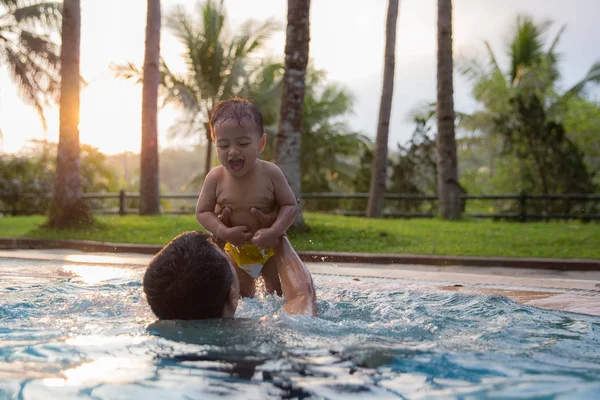 Padre e hijo disfrutando de la piscina — Foto de Stock